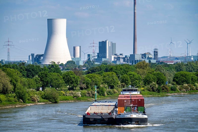 Cargo ship Mellizo, container freighter, only partly loaded, on the Rhine near Duisburg-Baerl, in the background the STEAG power plant Walsum North Rhine-Westphalia, Germany, Europe