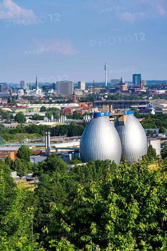 View of Dortmund city centre from the Deusenberg spoil tip, with the digestion towers of the Deusen Emscher sewage treatment plant in the foreground, North Rhine-Westphalia, Germany, Europe