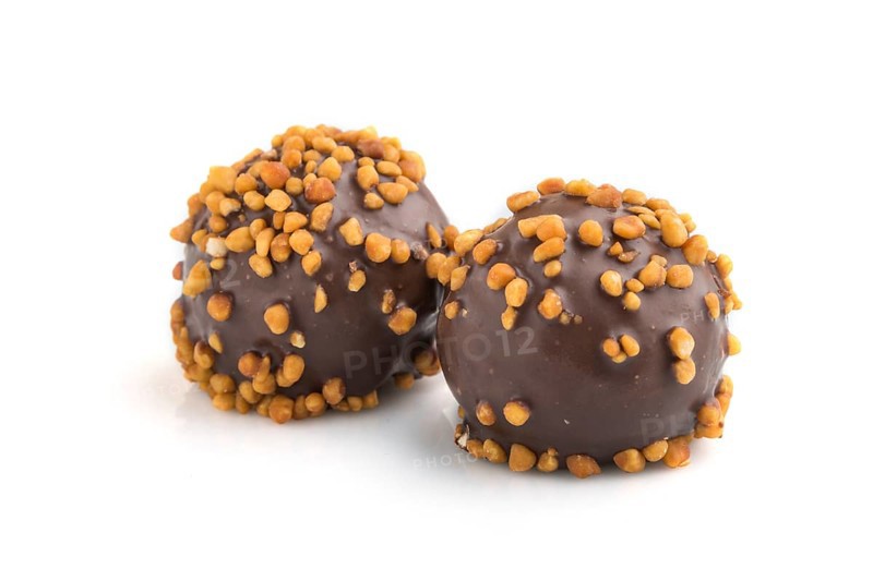 Chocolate caramel ball candies with almonds isolated on white background. Side view, close up