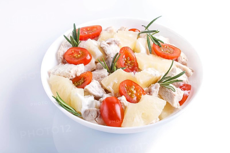 Chicken fillet salad with rosemary, pineapple and cherry tomatoes isolated on white background. close up