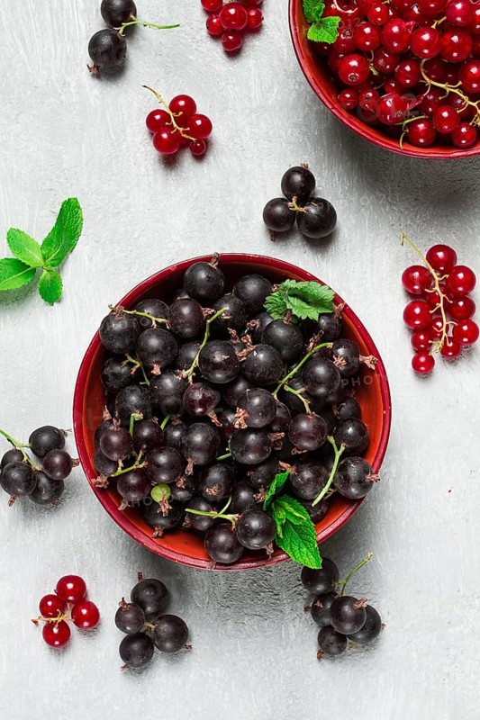 Bowls with berries, black and red currants, top view, food concept, no people