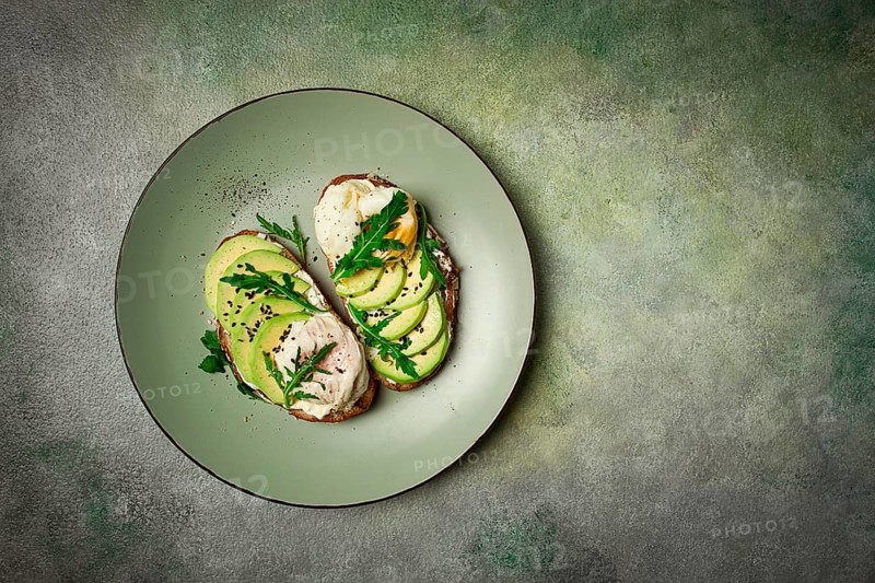 Sandwich with cream cheese, sliced avocado and boiled egg, arugula, on grainy bread, homemade, breakfast, no people