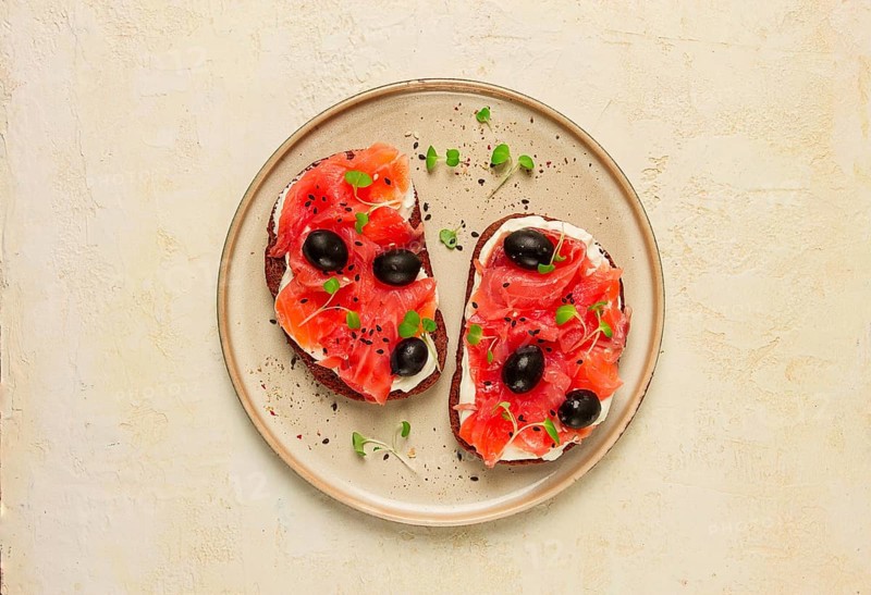 Sandwiches with red fish, cream cheese, olives and microgreens, breakfast