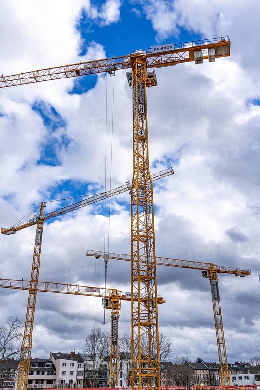 Construction cranes, on a large construction site in Düsseldorf, construction of condominium in the PANDION NEXT project, North Rhine-Westphalia, Germany, Europe