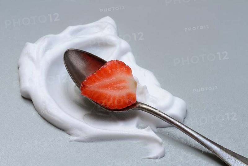 Strawberry with cream on a spoon