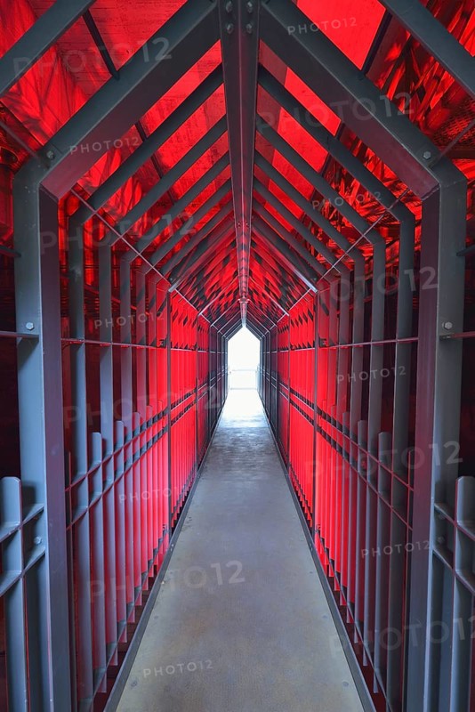 A long tunnel with red lighting and metallic structures conveys a futuristic and industrial atmosphere, Landschaftspark Duisburg Nord, Meiderich Hütte, Duisburg, Ruhr area, North Rhine-Westphalia, Germany, Europe