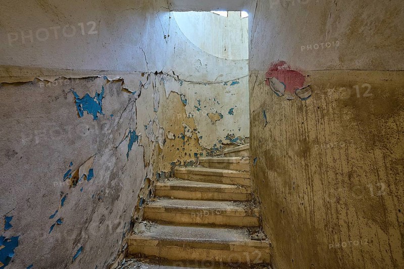 Dilapidated staircase with peeling paint and round window through which light enters, Lost Place, Former Santorium, Tuberculosis Centre 1947-1970, Former Italian colonial settlement, Eleousa, Campochiaro, Rhodes, Dodecanese, Greek Islands, Greece, Europe