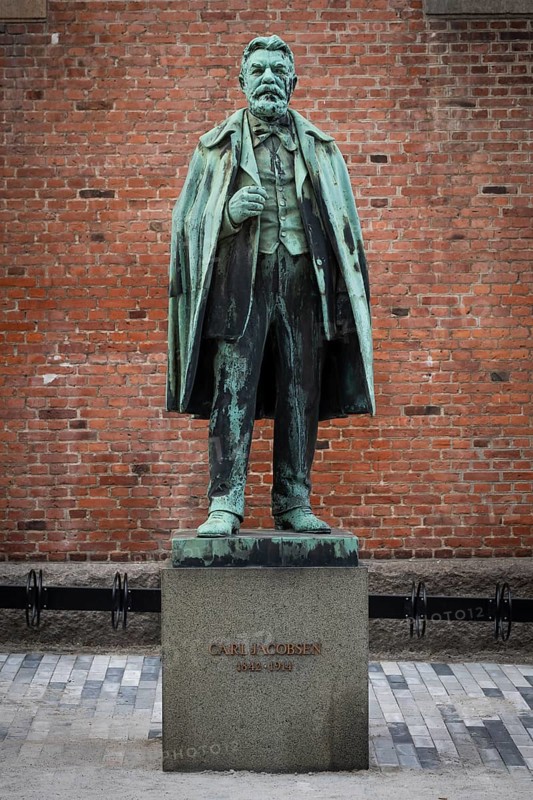 Bronze statue of Carl Jacobsen, Danish brewery entrepreneur, art collector and benefactor, in front of brick wall on plinth, Carlsberg district, Copenhagen, Denmark, Europe