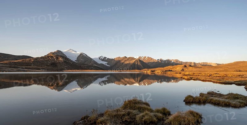 Glaciated mountain peaks reflected in a mountain lake at sunset, Arabel Lake at Arabel Pass, Issyk Kul Province, Kyrgyzstan, Asia