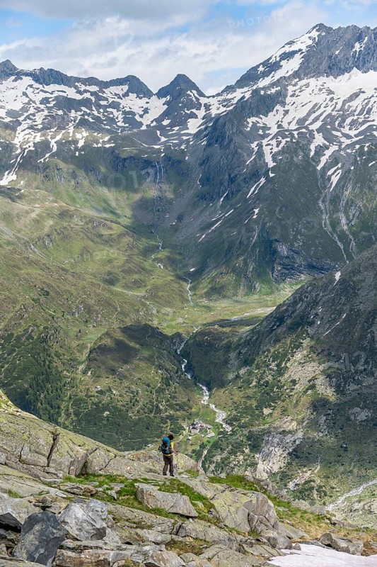 Mountaineer in front of picturesque mountain landscape, view of mountain hut Berliner Hütte with Zemmbach with rocky mountain peaks, Berliner Höhenweg, Zillertal Alps, Tyrol, Austria, Europe