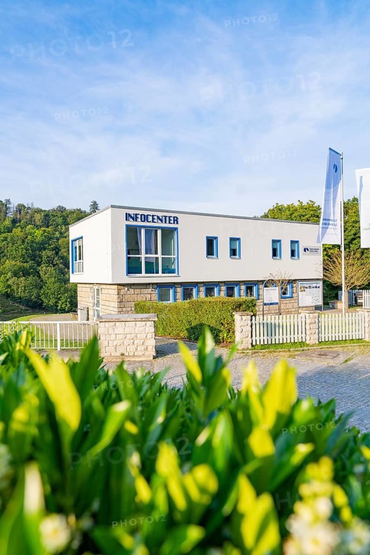 Modern information centre building with large glass windows and fences, surrounded by green nature, Harz Mountains, Germany, Europe