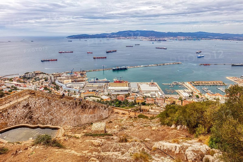 Panoramic view of a city by the sea with many ships and wooded hills, Gibraltar, Europe