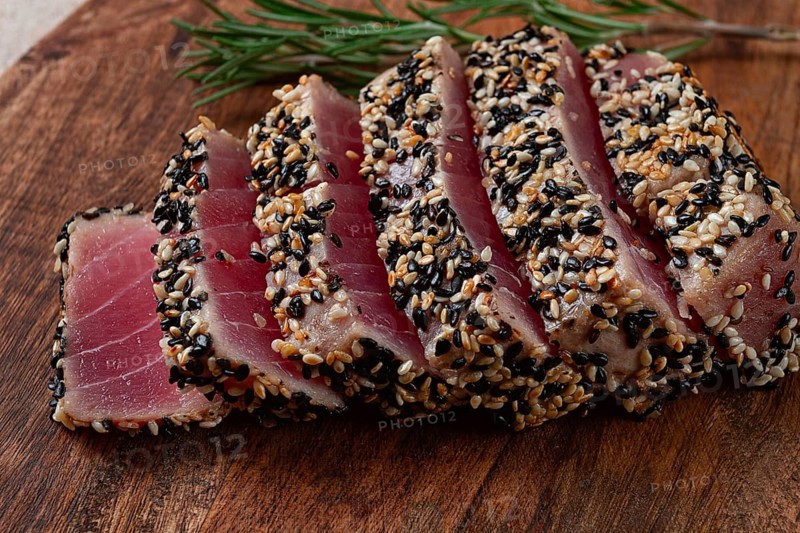 Fillet of red tuna meat, fried in sesame seeds, homemade, close-up, no people, on a wooden background