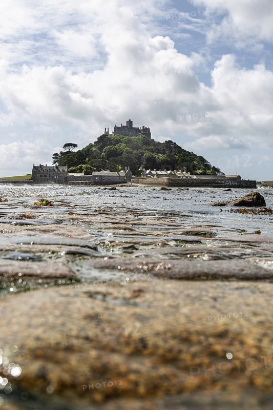 Medieval castle St Michael's Mount on a hill in the background, pebbles in the foreground, Cornwall, England, Great Britain