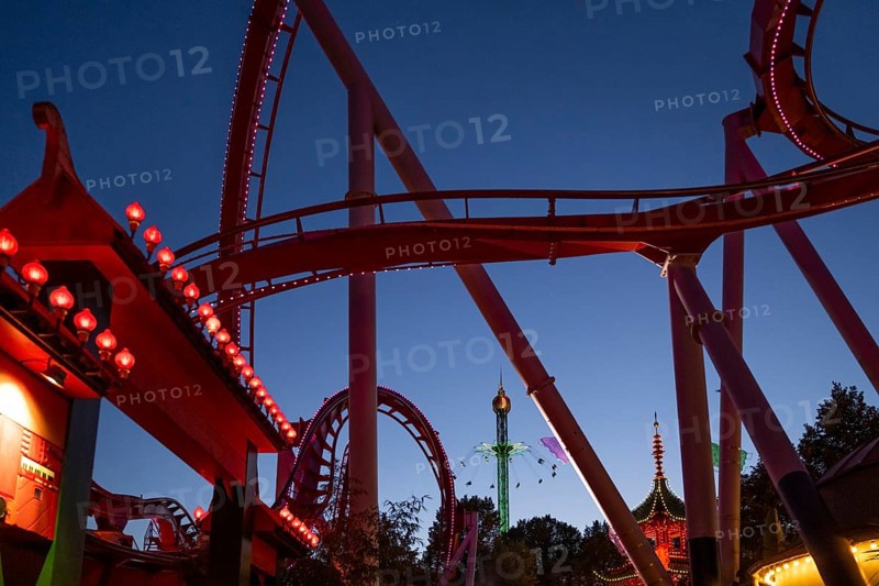 Roller coaster, chain carousel and pagoda at night, Tivoli Amusement and Recreation Park, Copenhagen, Denmark, Europe