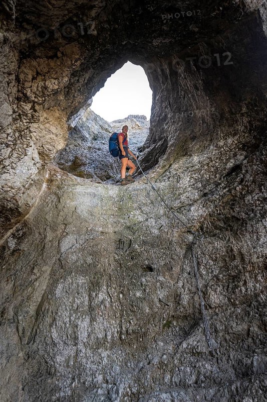 Hiker climbing through the Schindertor, Schinder, Tegernsee mountains in the Mangfall mountains, Germany, Europe