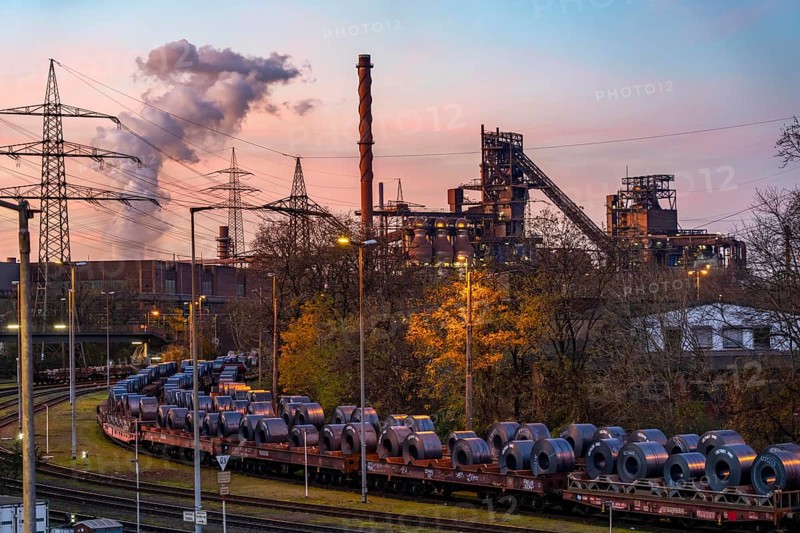 Blast furnace Schwelgern 1 and 2, strip steel coils, on freight wagons, at the ThyssenKrupp Steel plant Schwelgern in Duisburg-Marxloh, part of the Bruckhausen steelworks, in the background the cooling tower of the STEAG coal-fired power plant Walsum, North Rhine-Westphalia, Germany, Europe
