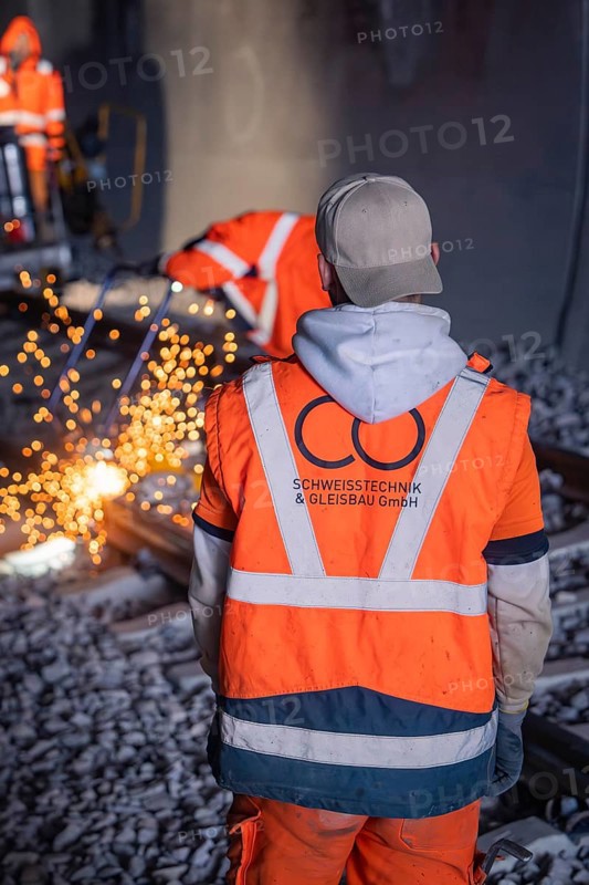 Worker in safety waistcoat observing welding work with sparks in the tunnel, rail welding, track construction Hermann Hessebahn, Calw, Black Forest, Germany, Europe