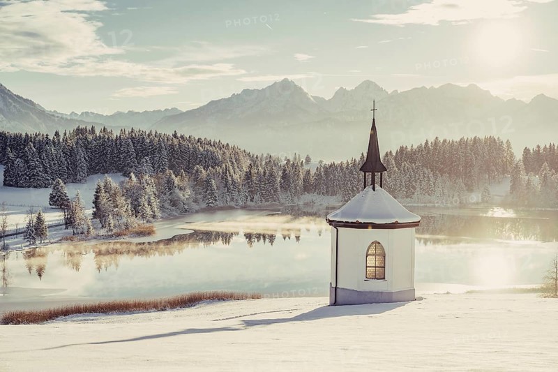 Chapel by the lake in the wintry snow-covered Allgäu near Halblech in front of an impressive mountain landscape, Bavaria, Germany, Europe