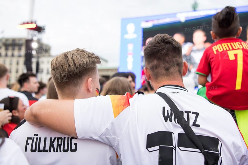 Two fans of the German team lie in each other's arms during the national anthem in the fan zone at the Brandenburg Tor tor during the round of 16 match between Germany and Denmark at the European Football Championship, Berlin, 29 June 2024