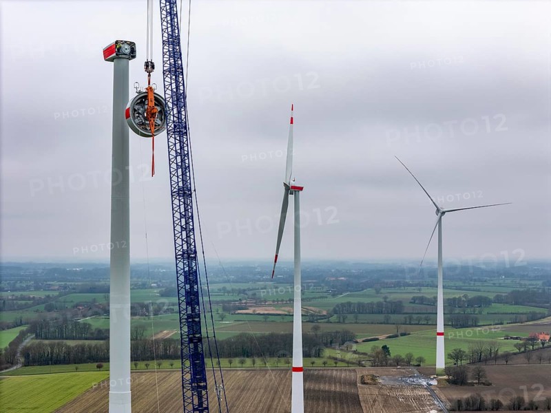 Assembly of an Enercon E-138 wind turbine, the stator, part of the generator is pulled to the nacelle by a large crawler crane, Ahlen wind farm, Münsterland, North Rhine-Westphalia, Germany, Europe