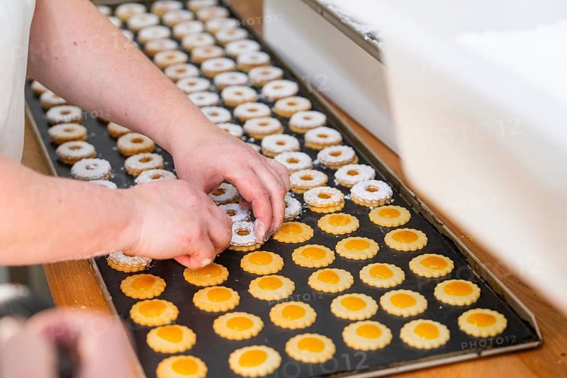 Two hands decorating double-layered round biscuits on a baking tray, Christmas baking, Black Forest, Germany, Europe