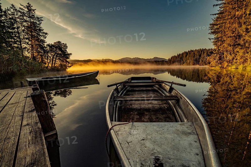Boats in the autumnal Schmutter Weiher in the Allgäu near the municipalities of Halblech, Roßhaupten and Lechbruck in Ostallgäu in the foothills of the Alps