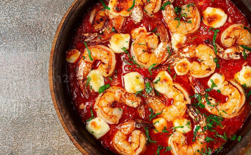 Saganaki with shrimp, in a clay pan, Greek dish, shrimp in tomato sauce, feta cheese, homemade, no people