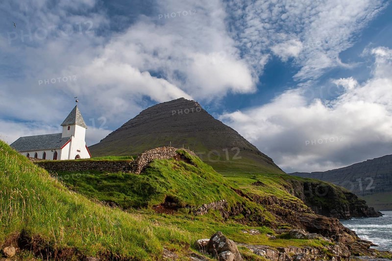Church against a dramatic mountain backdrop on the coast, Malinsfjall mountain, Vidareidi, Vidoy island, Viðareiði, Viðoy island, Faroe Islands, Denmark, Europe