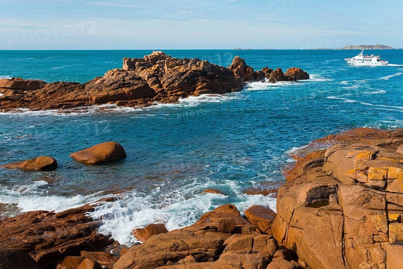 Coastline with rocks and passing boat under clear sky, Ploumanac'h, Ploumanach, Perros-Guirec, Côtes-d'Armor, Brittany, France, Europe