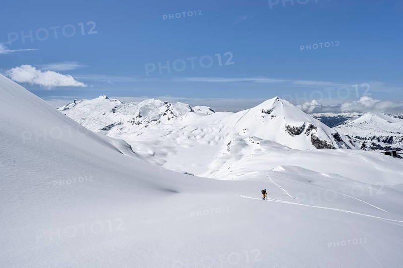 Lone ski tourer in mountain landscape with snow, summit Mittaghorn and Wildhorn, ascent to Wildstrubelhütte, Bernese Alps, Switzerland, Europe