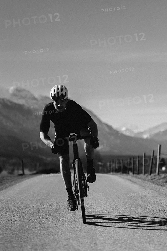 Road bike rider in spring near Halblech in the Allgäu in front of a picturesque backdrop of the Alps, Bavaria, Germany, Europe