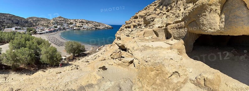 View of entrances of caves in sandstone rocks of former Roman necropolis with sandstone caves carved into sandstone Cave tombs Grottoes in rocks on the north side of Matala Bay, in the 60s and 70s hippie caves Caves for dropouts and hippies today excursion destination on the south coast of Crete island, left at the edge of the picture Libyan Sea Mediterranean, Matala, Crete, Greece, Europe