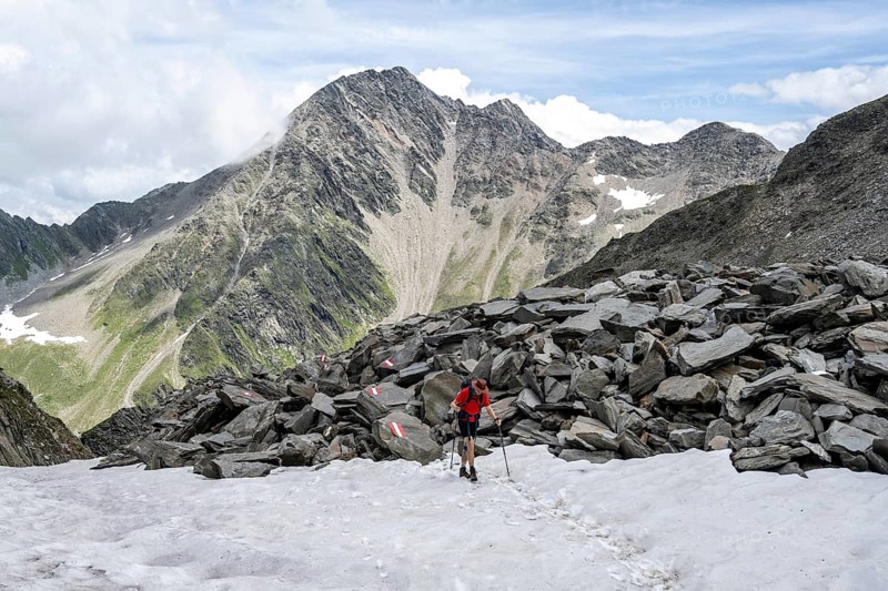 Hiker crossing a snowfield, Lasörling High Trail, Lasörling Group, Hohe Tauern National Park, East Tyrol, Tyrol, Austria, Europe
