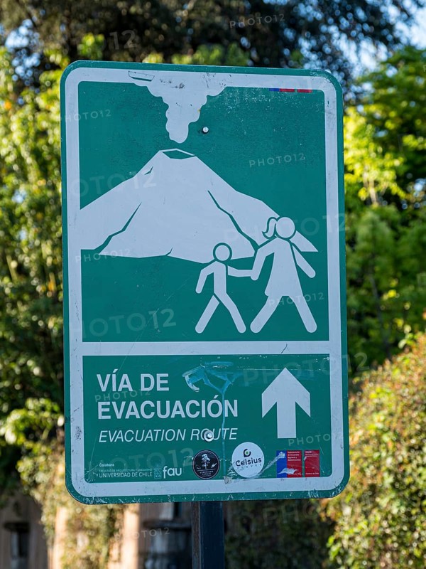 Signpost indicating evacuation route in case of a volcano eruption, Pucon, La Araucania, Chile, South America