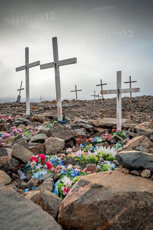 White crosses mark flower-decorated graves in a cemetery in foggy weather, remote Arctic Inuit settlement Ittoqqortoormiit, Scoresbysund or Scoresby Sund or Greenlandic Kangertittivaq, East Greenland, Greenland, North America