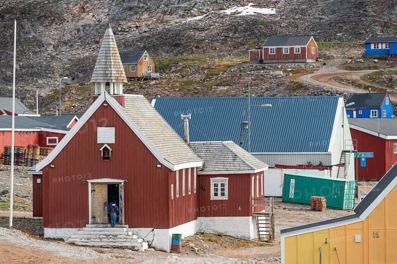 Red church with shingled roof and small colourful houses, remote Arctic Inuit settlement Ittoqqortoormiit, Scoresbysund or Scoresby Sund or Greenlandic Kangertittivaq, East Greenland, Greenland, North America