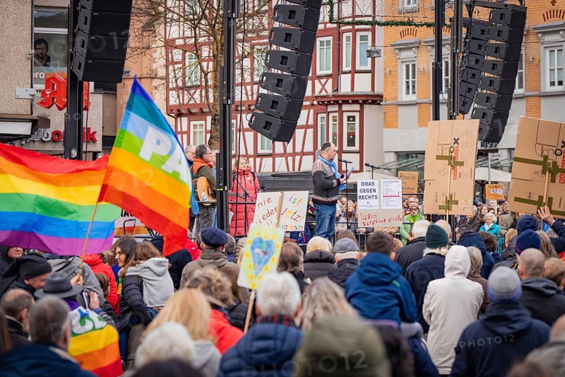Speaker on a stage at a demonstration, group of people with a large peace flag and banners, Against the Right demonstration, Nagold, Black Forest, Germany, Europe