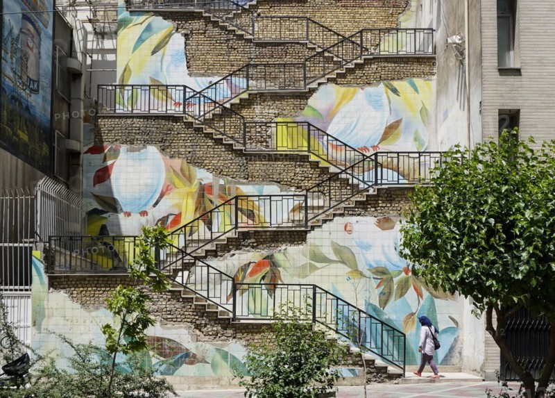 Passers-by walk up a staircase painted with roses in Tehran. The city of Tehran is changing the image of the city through art objects in public spaces, 17.05.2016
