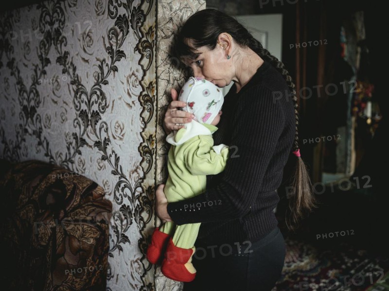 Tania with her daughter Polia. Tania is deaf. She was unable to leave the village of Voloska Balakliia on the front line for financial reasons, artillery fire can be heard every day, Voloska Balakliia, Kharkiv Oblast, Ukraine, Europe