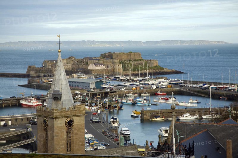 View over town and harbour to Castle Cornet with Sark beyond, St Peter Port, Guernsey, Channel Islands, UK, Europe
