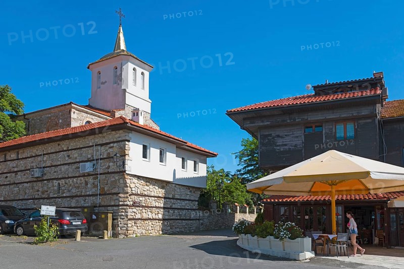 Historic church under clear blue sky next to urban buildings with people and parked cars, Orthodox Church of the Holy Virgin, Black Sea, Nesebar, Nessebar, Burgas, Bulgaria, Europe