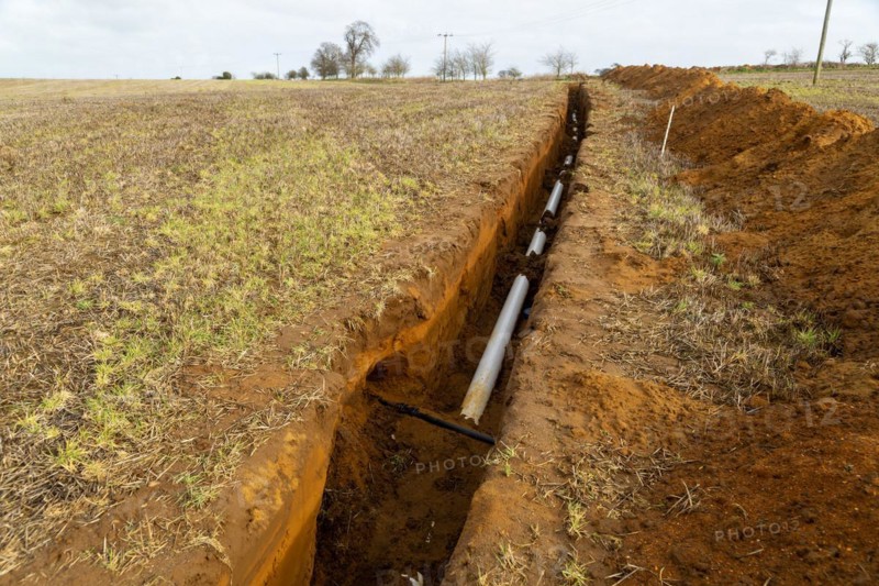 Farm irrigation water supply pipeline excavated in sandy soil, Shottisham, Suffolk, England, UK