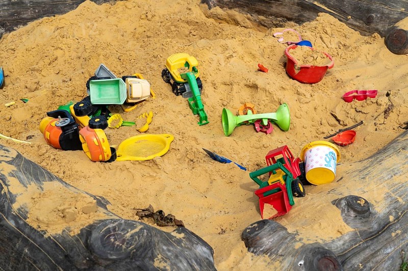 Sandpit, on a children's playground, sandpit with various plastic toys, excavator, shovels, moulds Sauerland, North Rhine-Westphalia, Germany, Europe