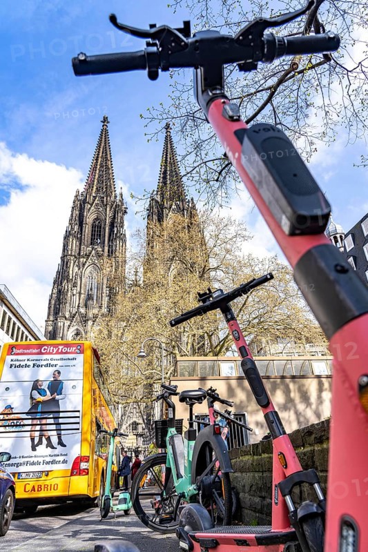 Electric scooters, e-scooters are parked in large numbers on the Burgmauer road, in front of Cologne Cathedral, legal parking area, partly signposted, Cologne, North Rhine-Westphalia, Germany, Europe