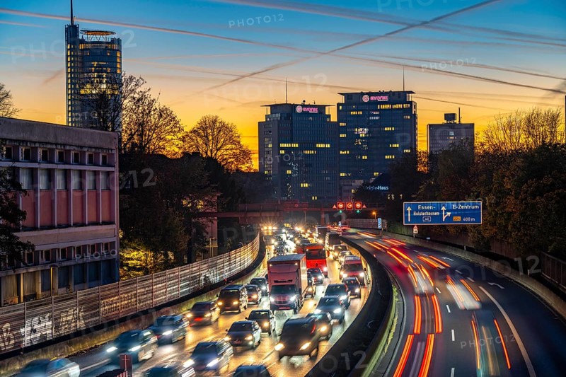 Evening traffic, partly with traffic jams, slow-moving traffic on the A40 motorway, skyline of Essen, left RWE tower, centre Evonik Group headquarters, Essen, North Rhine-Westphalia, Germany, Europe