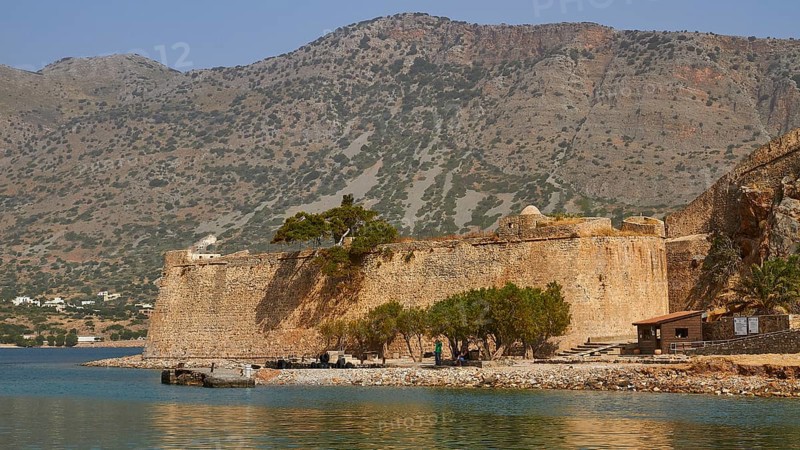 Old fortress on the coast, surrounded by trees and water, with hilly landscape in the background, Venetian Sea Fortress, Leper Island, Spinalonga, Elounda Bay, Mirabello Bay, East Crete, Crete, Greek Islands, Greece, Europe