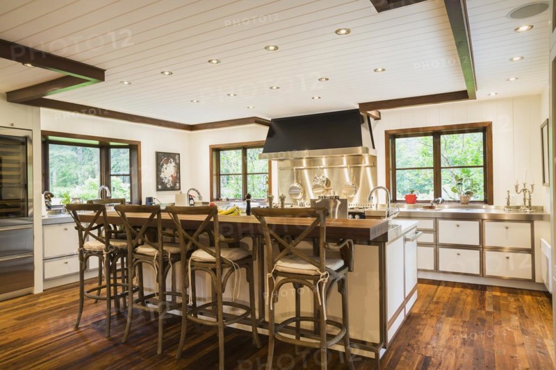 Country style kitchen with island and rustic wooden high chairs inside a New Hampton style home, Quebec, Canada, North America