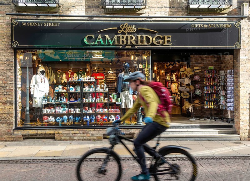 Little Cambridge gifts and souvenirs shop, Sidney Street, Cambridge, Cambridgeshire, England, UK cyclist passing blurred