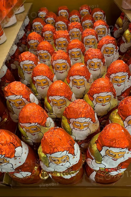 Display in shelf of wholesale retail of chocolate santa clauses chocolate santa clauses santa claus santa claus chocolate santa clauses in colour red of red staniol paper of chocolate brand Lindt arranged like army of santa claus, Germany, Europe